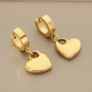 Detailed view of polished gold heart pendant earrings with sleek mirror finish surfaces