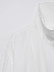 Detail of white linen bomber jacket showing collar cut and premium fabric texture