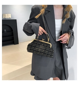 Detail of black plaid tweed handbag featuring a gold clasp closure and elegant chain strap
