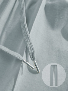Gros plan détaillé du pantalon décontracté bleu-gris avec cordon à embouts métalliques