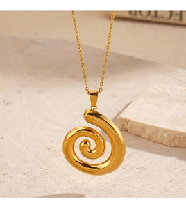 Makroaufnahme einer goldenen Spiral-Halskette auf beigem Stein mit warmer Beleuchtung