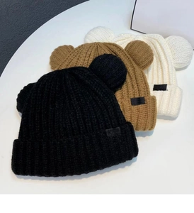 Détail de la maille des bonnets à oreilles d'ours en noir, marron et blanc cassé