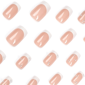 French tip press-on nails in nude pink with white edges and delicate pearl accents