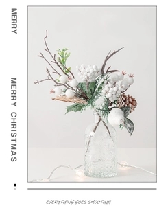 Close-up of white festive berries, pine cones and green leaves in a clear glass vase