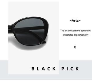 Close-up of minimalist black oversized sunglasses with thick frames and grey lenses