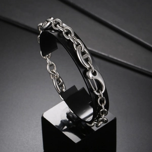 Industrial style silver stainless steel Cuban link bracelet on a sleek jewelry stand