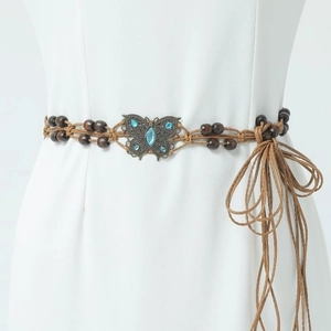 Detail of woven leather waist chain featuring butterfly metal buckle and wooden beads