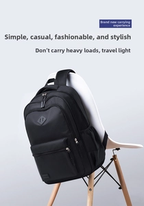 Close-up of black nylon backpack on white chair showing durable zippers and mesh pocket