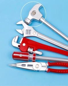 Macro detail of ballpoint pens shaped like silver tools with red handles and magnets