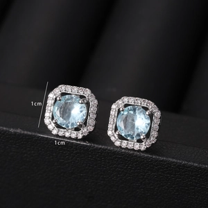 Macro shot of a 1cm silver stud earring featuring a blue stone and crystal halo detail