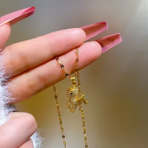 Macro detail of gold unicorn necklace with white cubic zirconia pavé and golden wings
