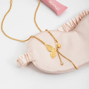 Detail of 18K gold butterfly paperclip necklace with heart charm and crystals
