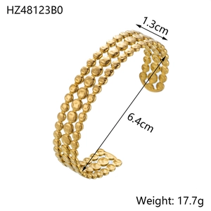 Detail view of a vintage gold stainless steel triple-row beaded open bangle bracelet