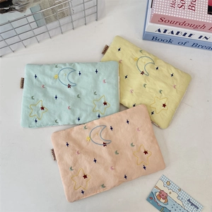 Detailed embroidery of stars and moon on fabric passport holders in three pastel colors