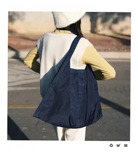 Detail of dark blue oversized tote bag with unique pleated texture in street style