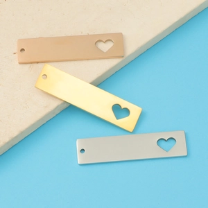 Macro detail of rectangular tags with hollow heart design in gold rose gold and silver