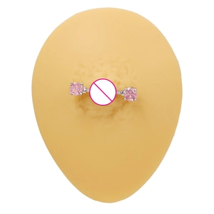 Vue macro d'un piercing de téton en acier inoxydable avec cristaux roses étincelants