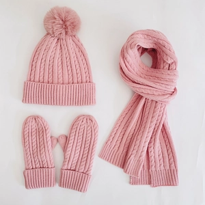 Pink winter knit set including pompom beanie, scarf, and mittens with cable pattern