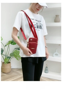Red multi-layer nylon cell phone crossbody bag worn on a white casual t-shirt