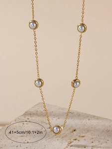 Detailed view of golden pearl necklace hanging on stone with 41+5cm length measurement