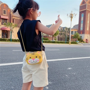 Dettaglio mini borsa a tracolla tigre gialla con catena dorata su modella bambina