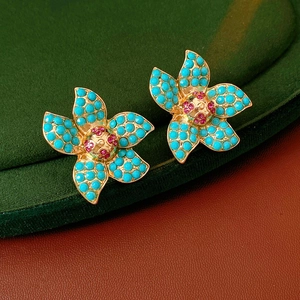 Detailed close-up of vintage flower earrings with blue petals and golden base
