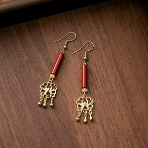 Detail of Chinese style tassel earrings with red beads and golden floral hollow pendant