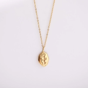 Detail of vintage gold stainless steel necklace featuring a 3D rose flower engraved pendant