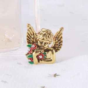 Retro angel brooch with red flowers and green leaves on a white sequin fabric background