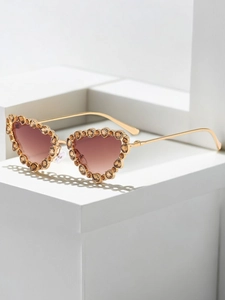 Detailed view of heart-shaped metal frame with amber rhinestones and gold temples