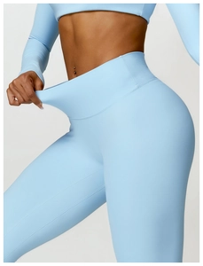 Detail shot of high-waist light blue yoga pants showing strong stretch and shaping fabric