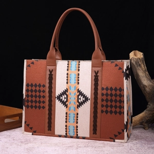 Detail of bohemian tote bag featuring ethnic patterns and sturdy brown leather handles
