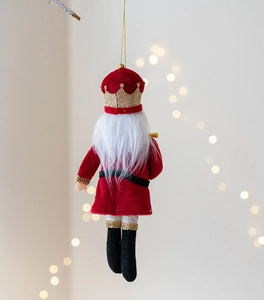Detail of fabric Nutcracker soldier ornament with sequins and gold hanging string