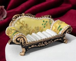 Macro detail of yellow vintage sofa ring display box with golden floral embroidery