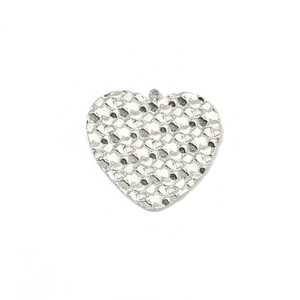 Macro shot of polished silver heart pendant with unique hammered texture and metal shine