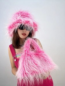 Detail of hot pink faux fur bucket hat and matching plush handbag set on model