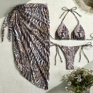 Detailed flat lay of leopard print three-piece bikini set with a sheer mesh beach sarong
