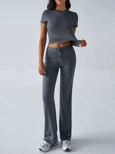 Detail of grey short-sleeve top and flared drawstring pants set on a female model