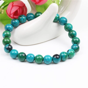 8mm Lapis Lazuli beaded bracelet for men on a white ceramic hand display with roses