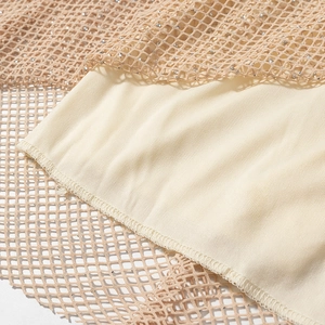 Macro detail of beige sequined mesh fabric with smooth lining and neat stitching