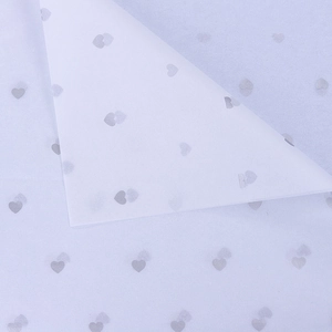 Macro shot of semi-transparent white tissue paper with elegant silver heart patterns