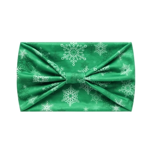 Detail of green yoga headband with white snowflake patterns and soft knotted fabric texture