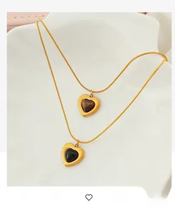 Detail of vintage heart pendant necklaces with tiger eye stone and black onyx in gold frame