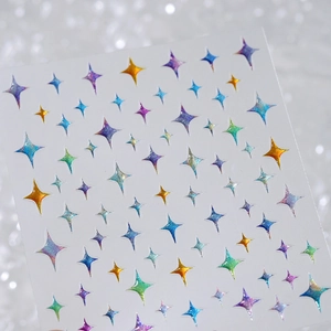 Colorful star-shaped nail art stickers with glitter finish on silver background