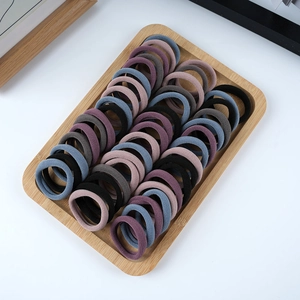 50-pack thick high-elastic towel rings for women in various colors on a wooden tray