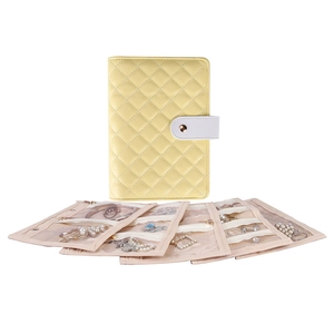 Detail of yellow quilted jewelry binder with clear pockets for rings and necklaces