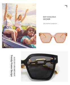 Detail view of pink square frames and black sunglasses with thick gold chain decoration