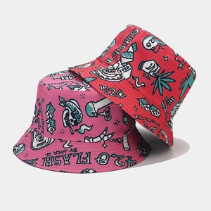 Detail of pink and red reversible bucket hats with graffiti and cannabis leaf patterns