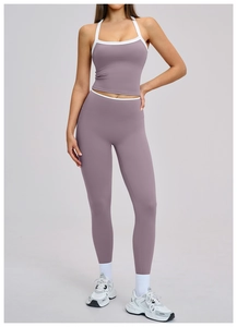 Detail van een dusty paarse yogaset met cross-back bh en legging met witte biezen