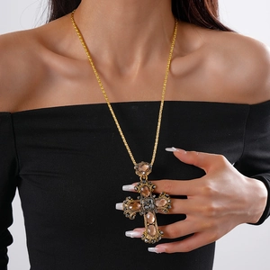 Close-up of a vintage baroque cross pendant with champagne stones on a gold chain